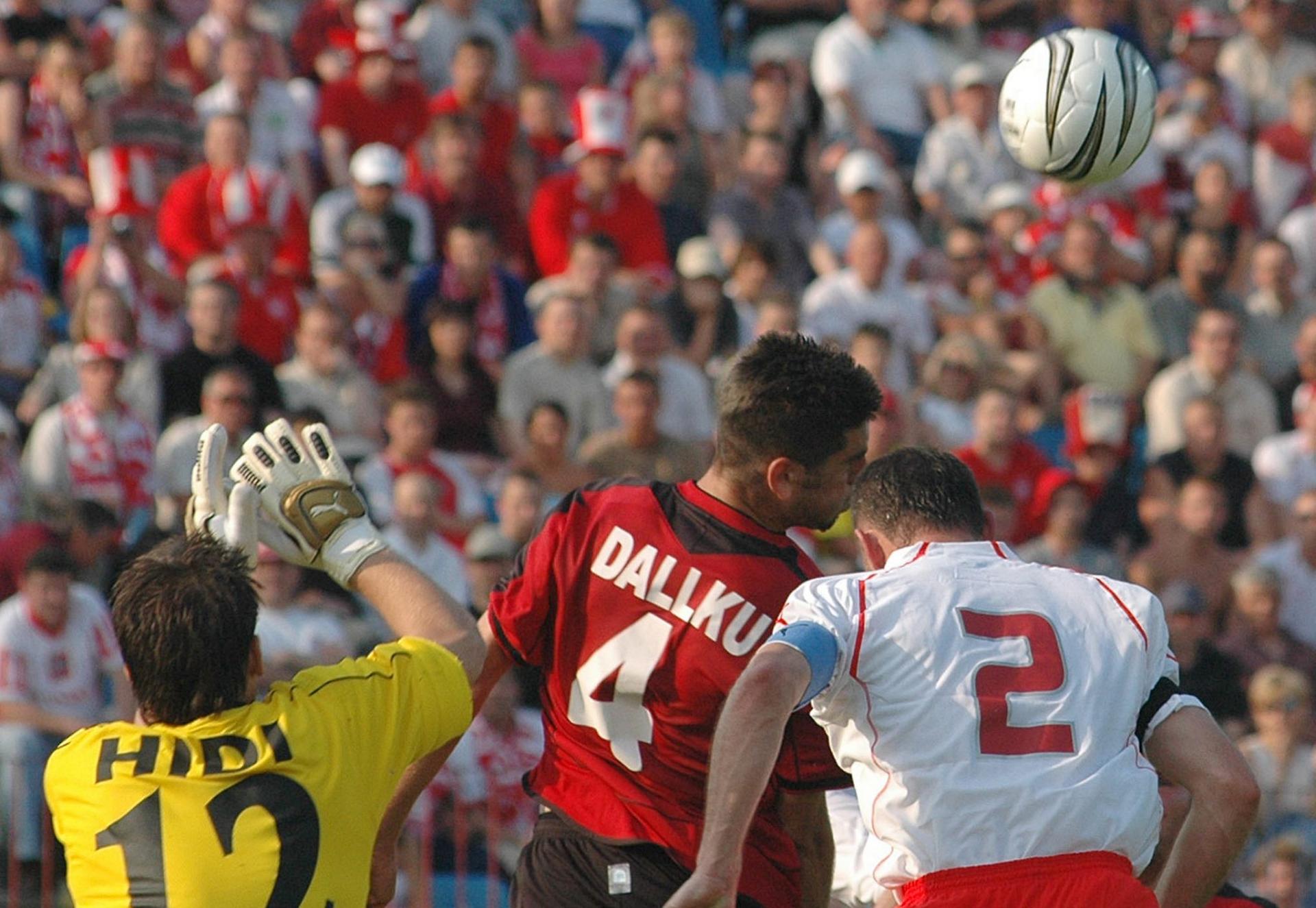 Tomasz Kłos w walce o górą piłkę z Islim Hidim i Armendem Dallku podczas meczu Polska - Albania 1:0 (29.05.2005).