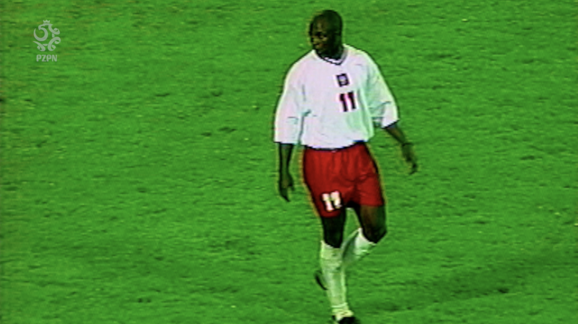 Ciemnoskóry Emanuel Olisadebe w biało-czerwonym stroju na zielonej murawie