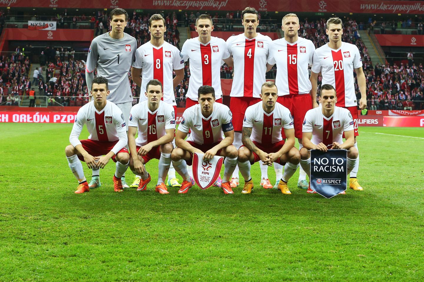 Reprezentacja Polski w białych koszulkach z czerwonym pionowym pasem pośrodku, orzełkiem na piersi, pozuje do zdjęcia przed meczem ze Szkocją.