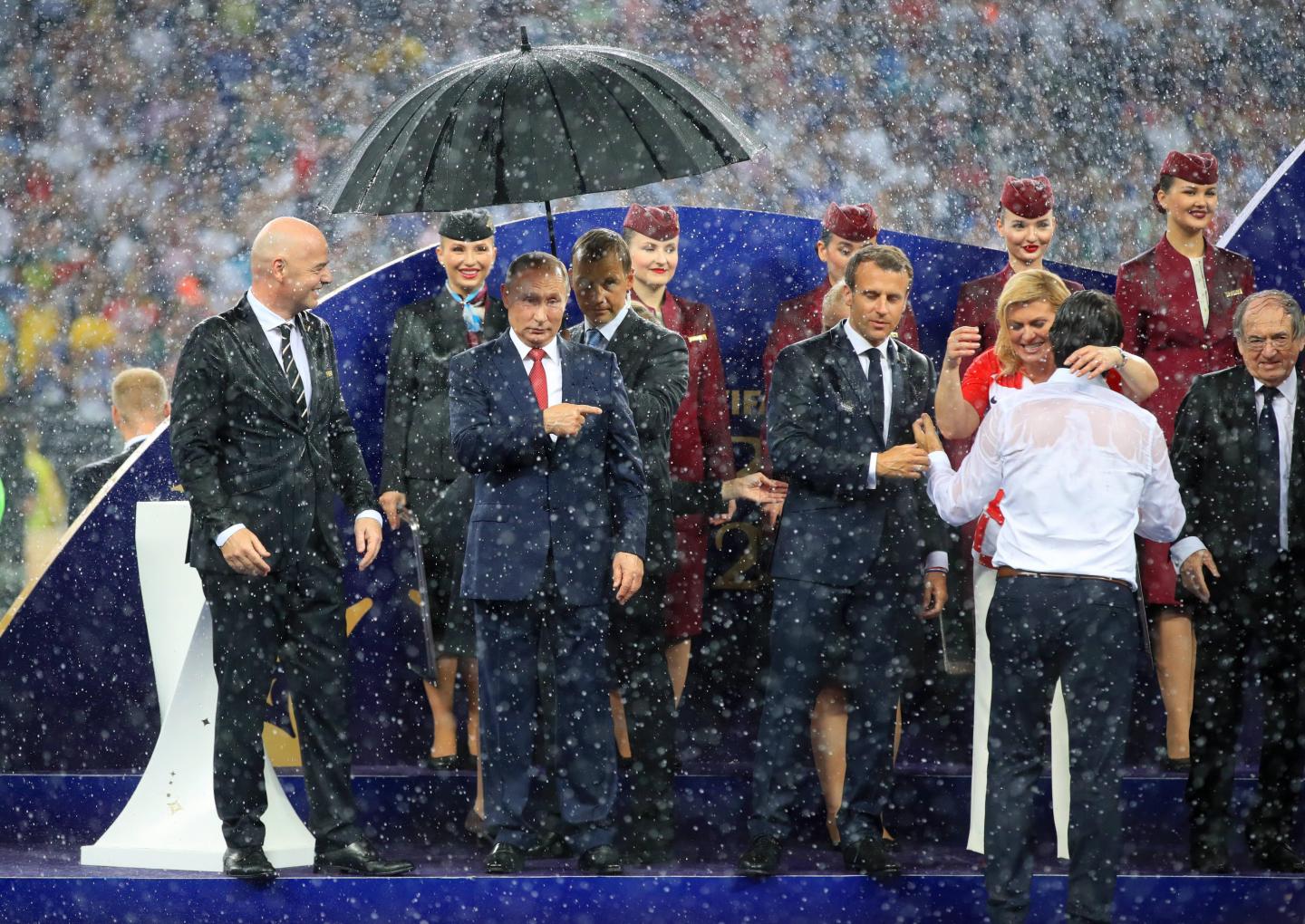 Władimir Putin osłonięty parasolem.