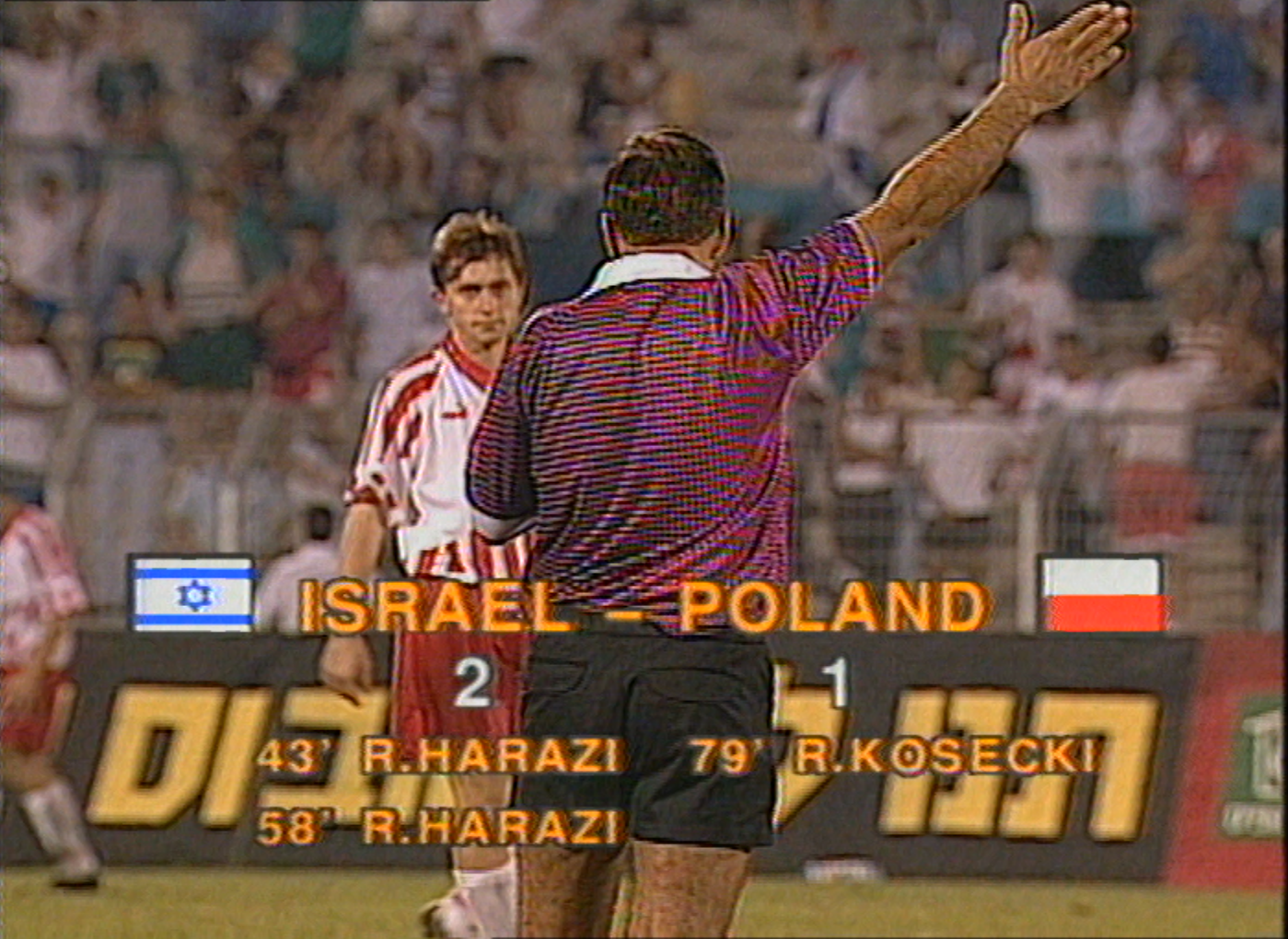 Ostatni gwizdek sędziego w Ramat Gan. Zmartwiony Jerzy Brzęczek. Na ekranie widoczny wynik Izrael - Polska 2:1 oraz strzelcy goli.