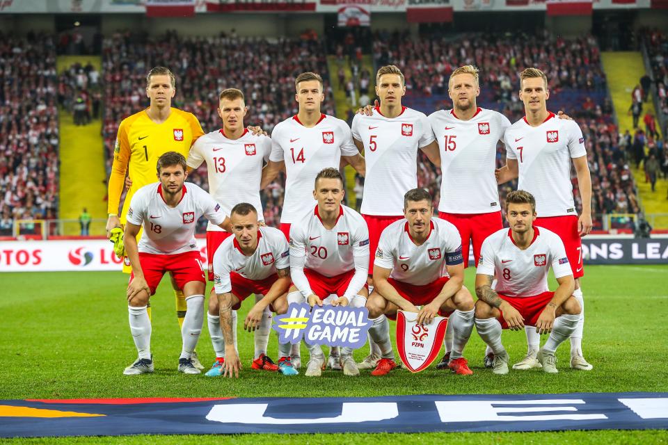 Reprezentacja Polski przed meczem z Włochami w Lidze Narodów UEFA. Polacy w białych koszulkach i czerwonych spodenkach.