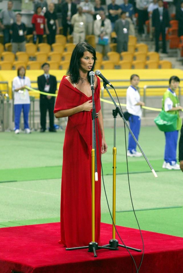 Edyta Górniak, ubrana w czerwoną sukienkę, śpiewa hymn Polski przed meczem MŚ 2002 z Koreą Południową.