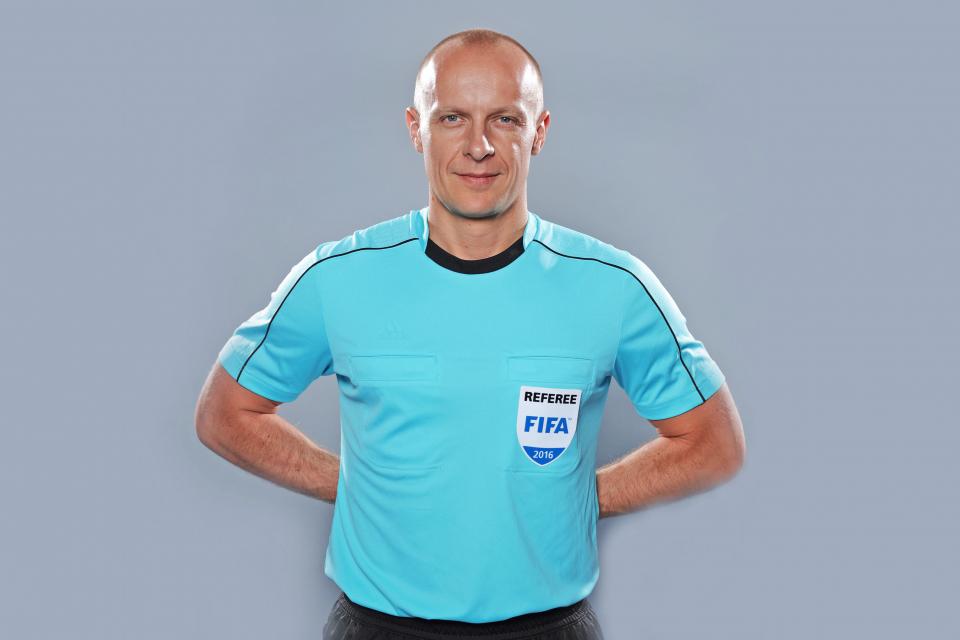 Sędzia Szymon Marciniak ubrany w jasnoniebieską koszulkę i czarne spodenki. Sesja przed Euro 2016.