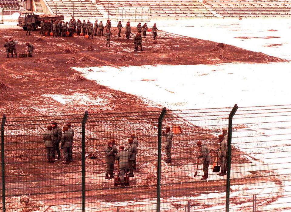 Żołnierze z łopatami odśnieżają murawę stadionu przy Łazienkowskiej 3 w Warszawie przed meczem Ligi Mistrzów z Panathinaikosem.