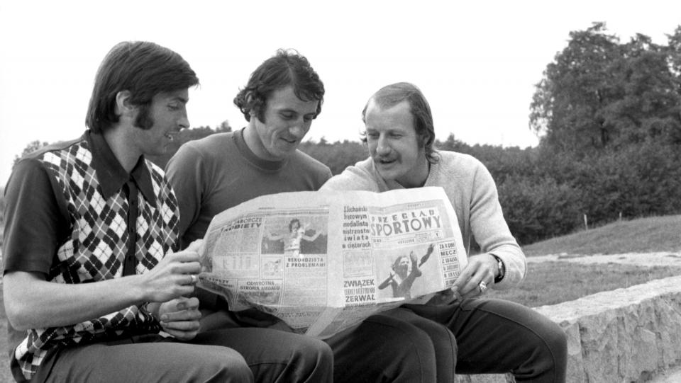 Kazimierz Deyna, Adam Musiał i Robert Gadocha przeglądający wspólnie gazetę.