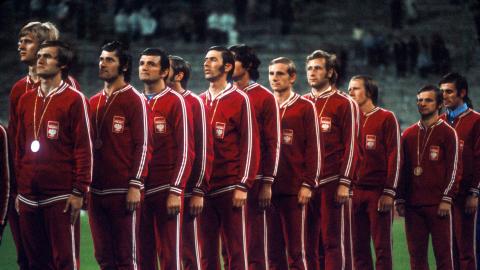 Polska reprezentacja (w czerwonych dresach) ze złotymi medalami podczas odgrywania hymnu.