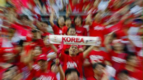 Kibic Korei Południowej z szalikiem reprezentacji. Zdjęcie zrobione na trybunach stadionu w Daegu.